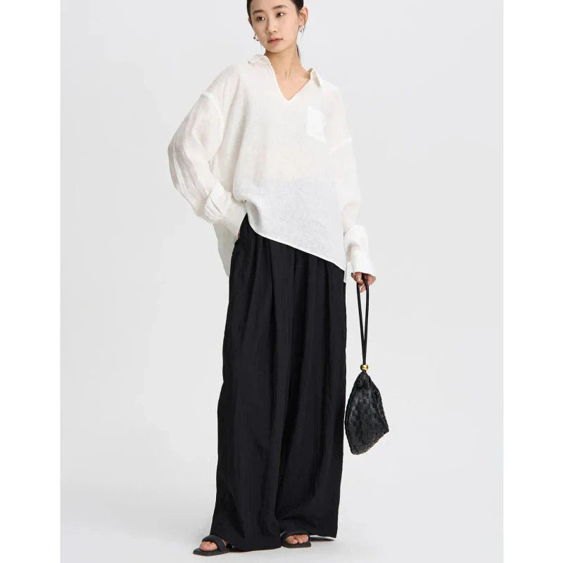 Pleated wide-leg high-waisted trousers in a herringbone plaid pattern, featuring a flattering silhouette and comfortable cotton-linen blend