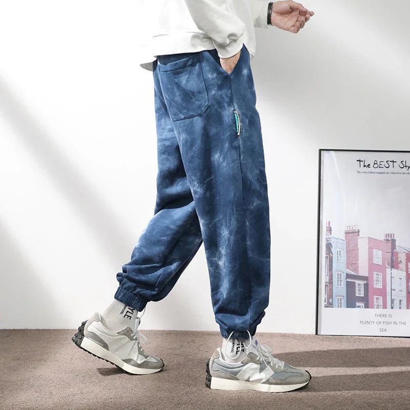 Stylish ankle-tied sweatpants in camouflage black, featuring an elasticated waistband, drawstring, and ankle ties for a relaxed yet refined look.
