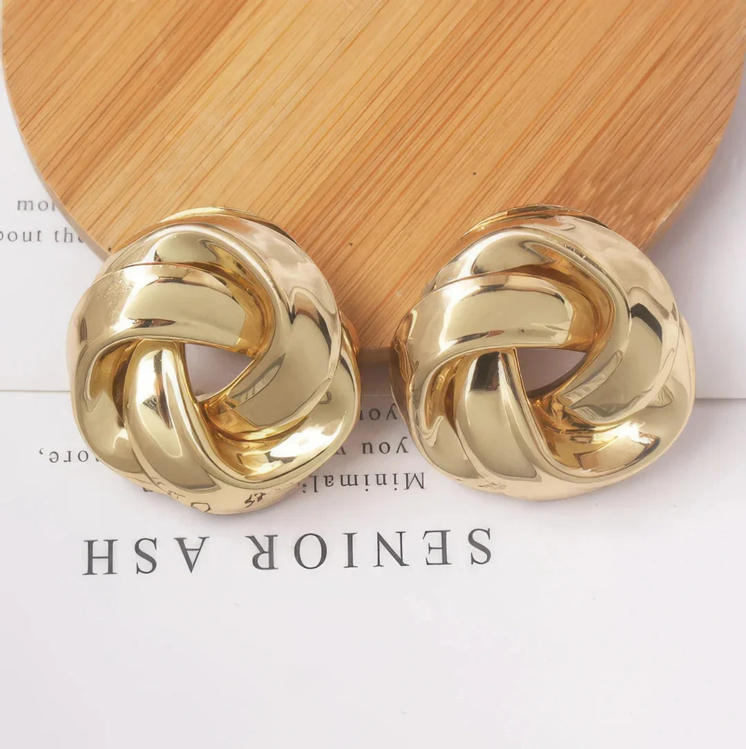 Pair of gold spiral drop earrings with an exaggerated, dramatic design for a bold, fashionable look