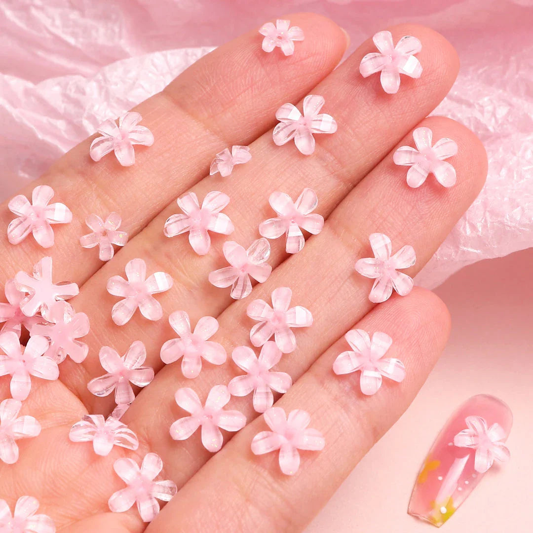 Elegant 3D flower nail charms in white and pink colours, featuring a transparent jelly finish and rhinestone accents for a stylish manicure