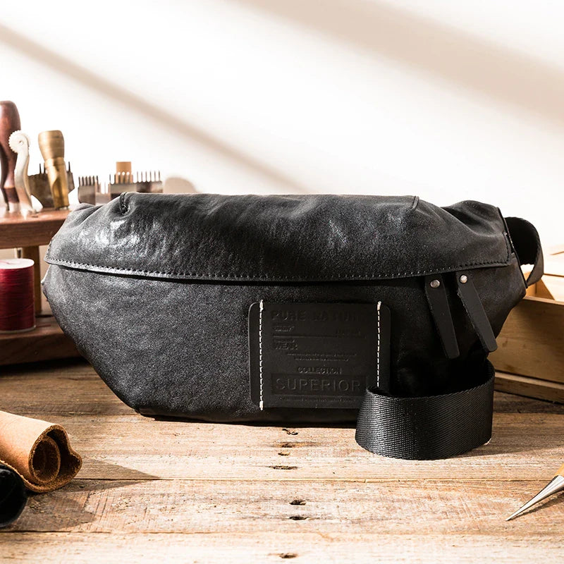 Premium cowhide messenger bag in black, featuring a spacious interior, adjustable shoulder strap, and sleek, minimalist design