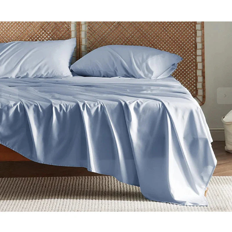 Premium bamboo fibre bed sheets in a classic solid purplish blue colour, featuring a four-piece set including a fitted sheet, flat sheet, and two pillowcases.