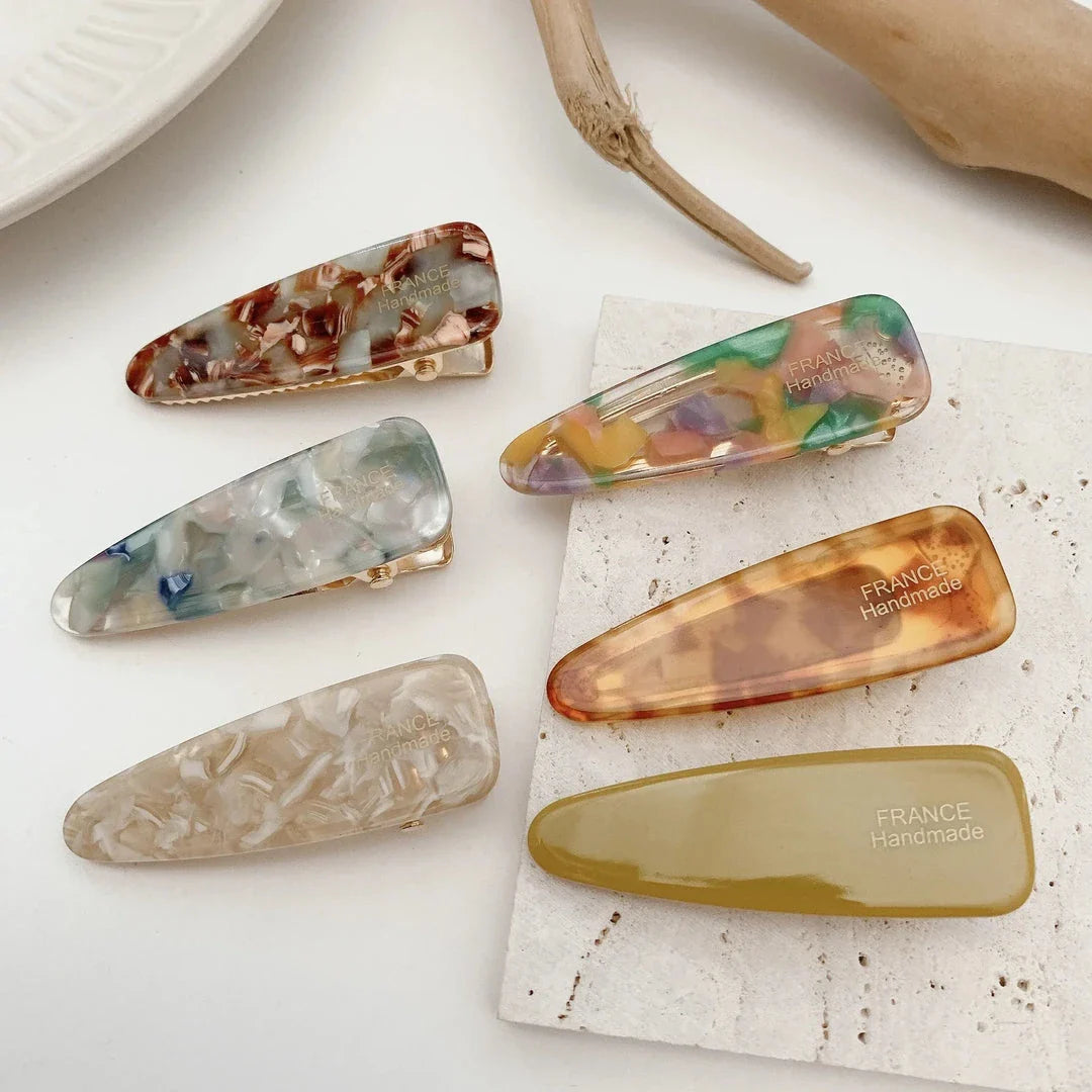 Two marble-patterned hair clips in a contemporary geometric design, made from high-quality acetate and acrylic materials.