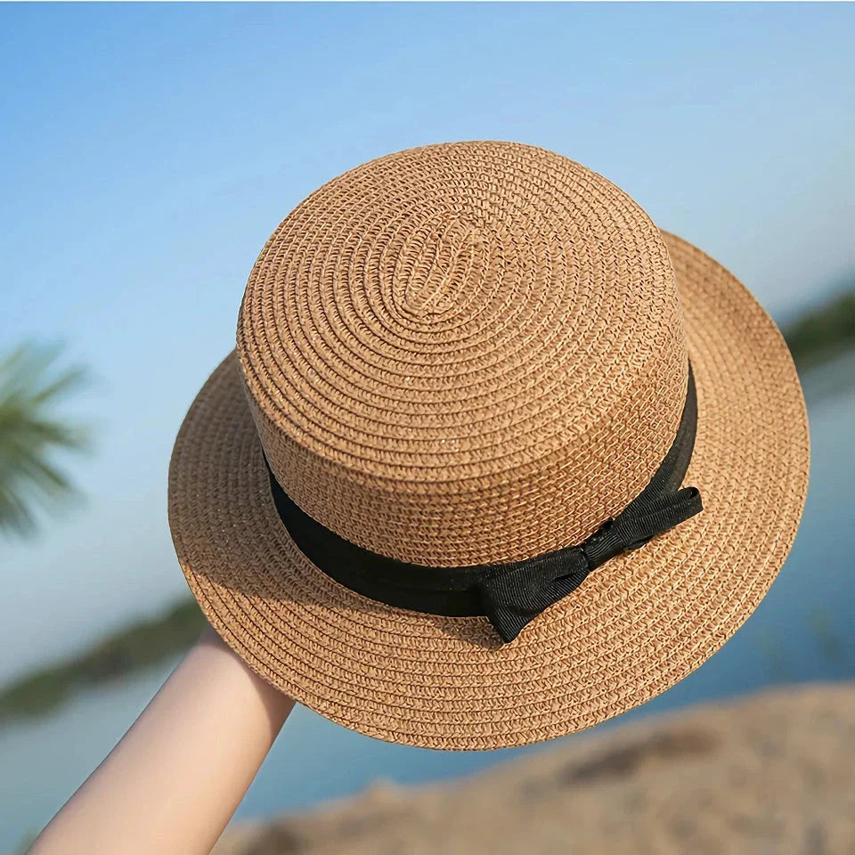 A classic summer Panama hat made from straw and paper, featuring a charming bow detail that adds a feminine touch.