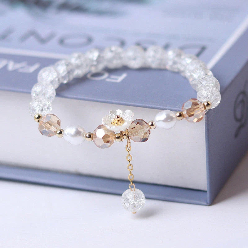 Elegant beaded bracelet with a white flower charm, vibrant purple crystal beads, and an adjustable design for a comfortable fit