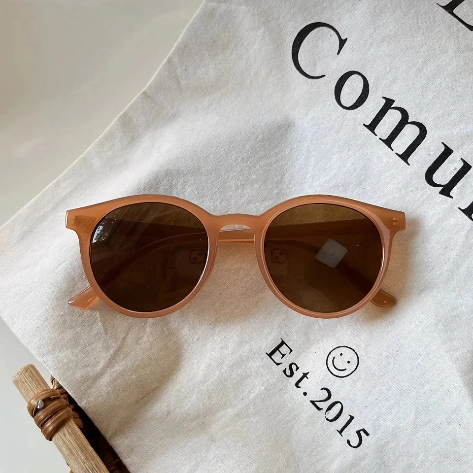 A pair of stylish, retro-inspired round sunglasses with a white frame, providing UV protection and a chic, contemporary look.