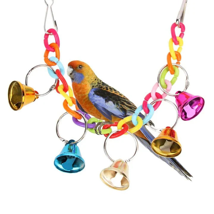 Acrylic bird bells swing with intricate design, hanging in a lush garden setting