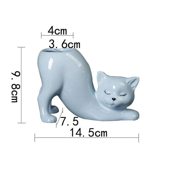 A white ceramic flower pot with a playful cartoon cat design and a functional tail element, perfect for desktops and small spaces.
