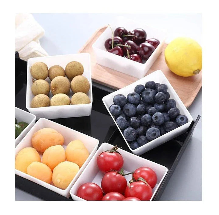 Premium British plastic snack trays in a variety of colours, including clear, white, and grey, with a black, white, or natural wood pallet for storage and display.