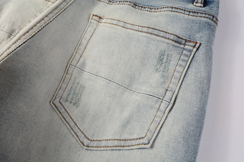 Stylish ripped denim jeans with a unique black and white patch design, perfect for British gentlemen