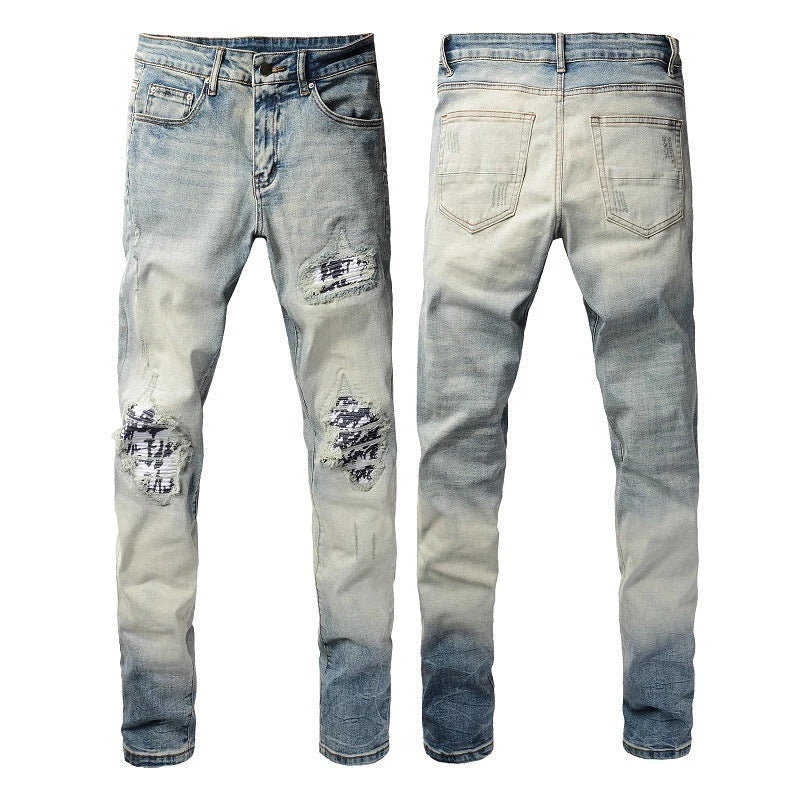 Stylish ripped denim jeans with a unique black and white patch design, perfect for British gentlemen