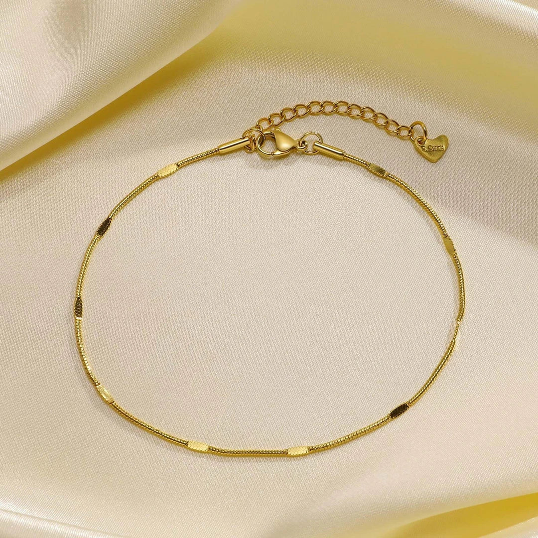 Elegant gold stainless steel minimalist anklet with delicate charm, adjustable length, and durable construction