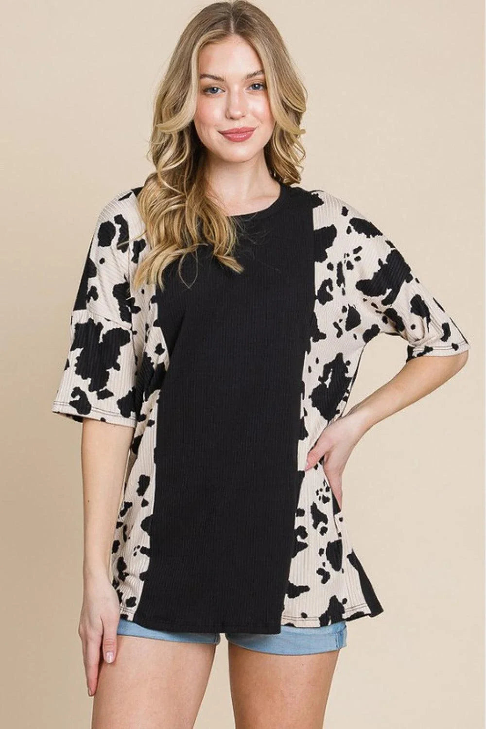 Stylish ribbed tee with playful cow print design, perfect for casual and smart-casual occasions.