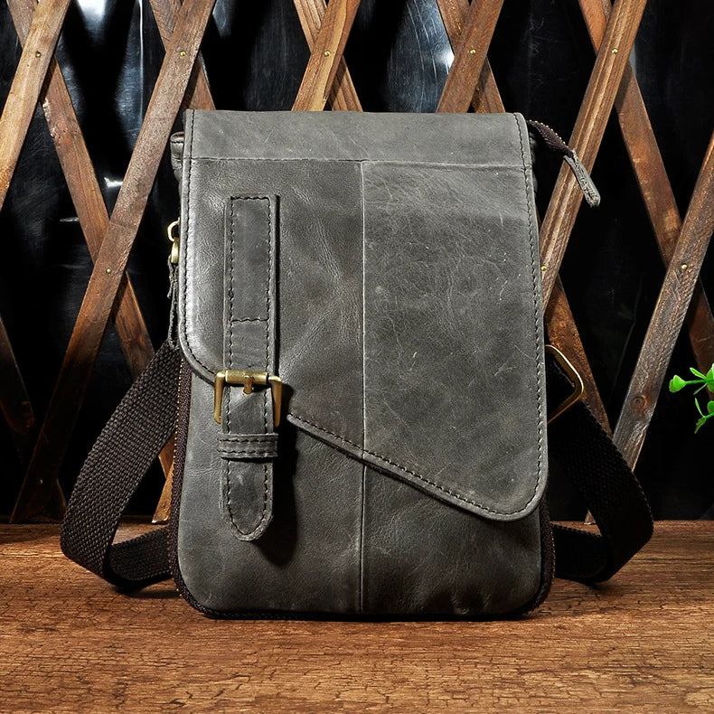 Premium cowhide leather one-shoulder crossbody bag in light grey colour with adjustable strap and zipper pocket