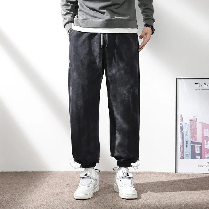 Stylish ankle-tied sweatpants in camouflage black, featuring an elasticated waistband, drawstring, and ankle ties for a relaxed yet refined look.