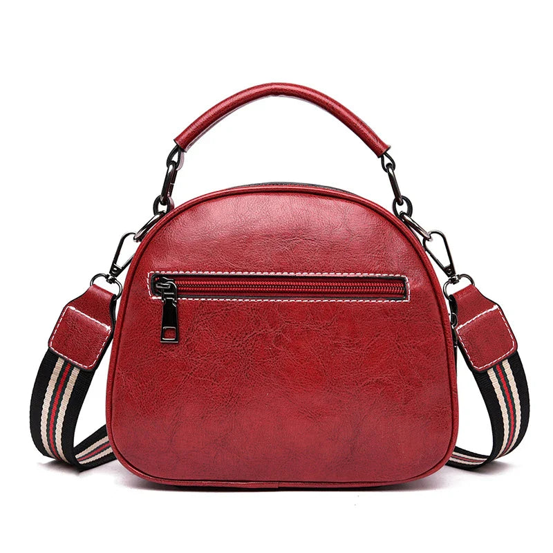 A stylish and versatile stitched shoulder bag in a classic brown colour, featuring a sleek oval shape and multiple interior compartments for organised storage.