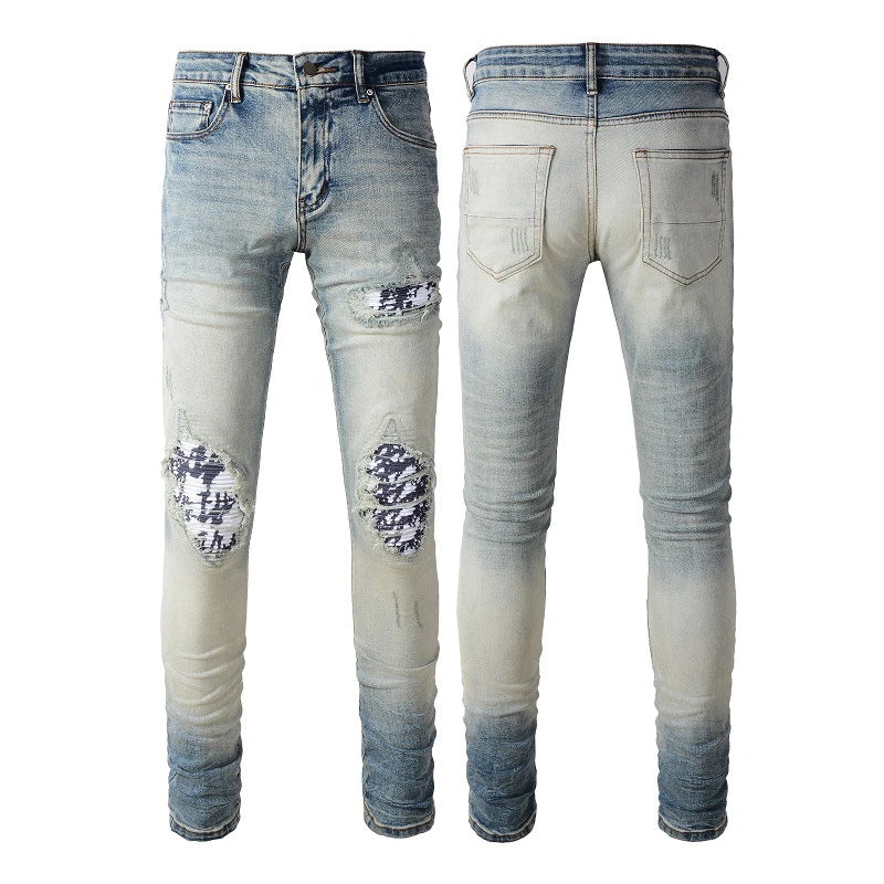 Stylish ripped denim jeans with a unique black and white patch design, perfect for British gentlemen
