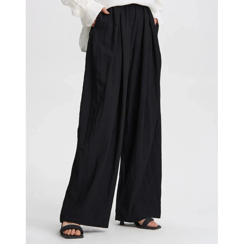 Pleated wide-leg high-waisted trousers in a herringbone plaid pattern, featuring a flattering silhouette and comfortable cotton-linen blend