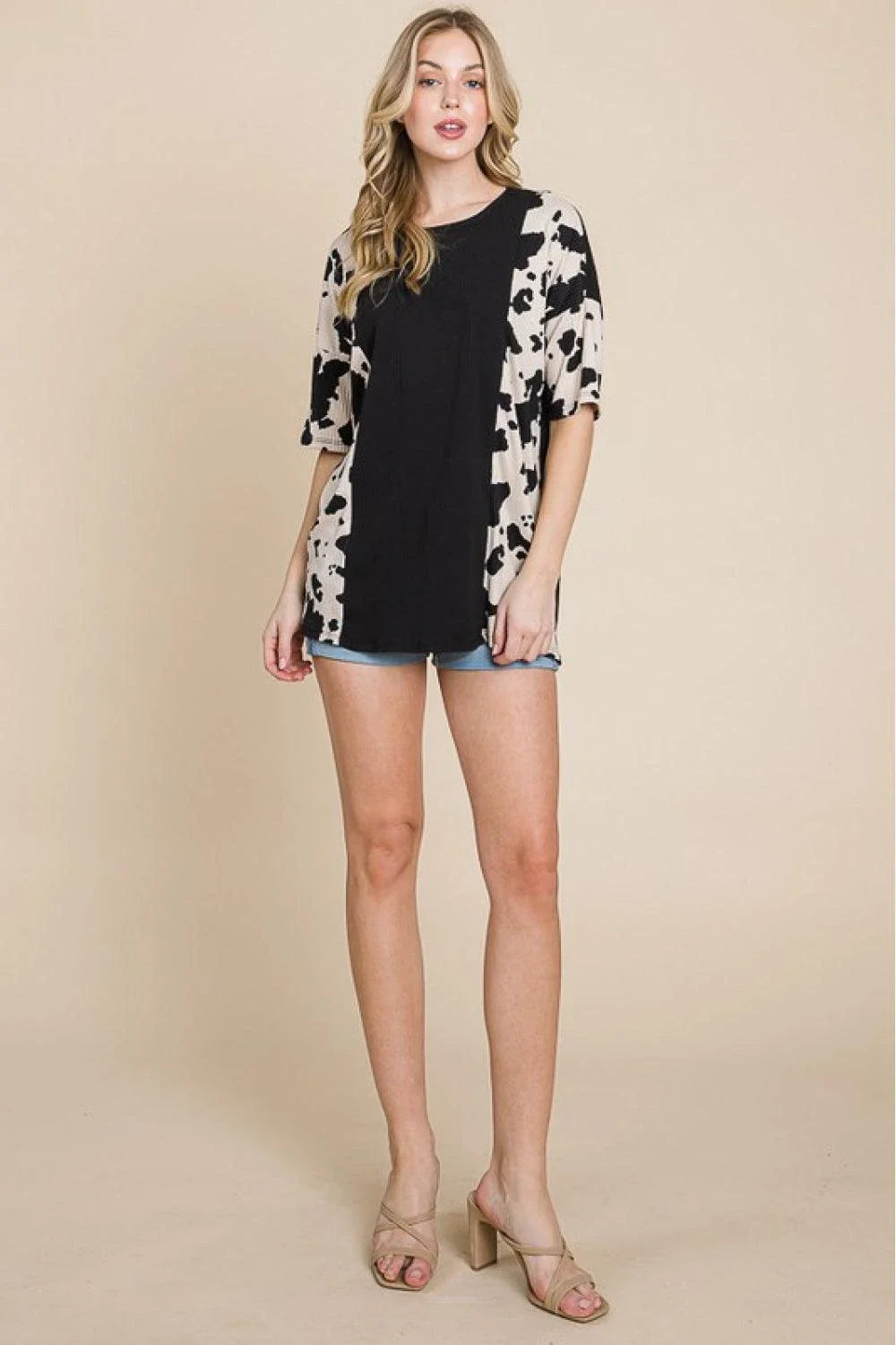Stylish ribbed tee with playful cow print design, perfect for casual and smart-casual occasions.