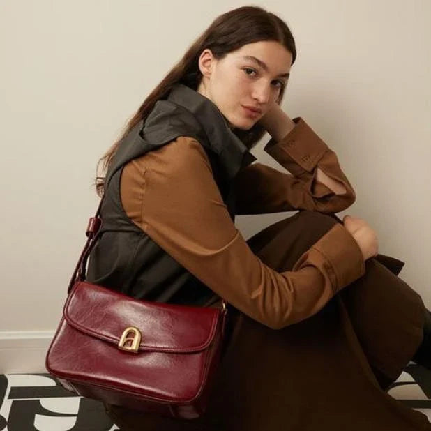 Stylish leather shoulder and crossbody bag in burgundy colour, with a square silhouette and sleek design
