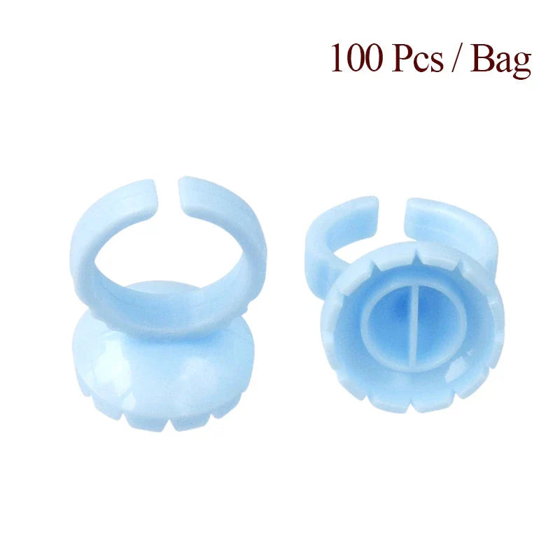Heart-shaped disposable eyelash glue rings in blue, pink, and white colours