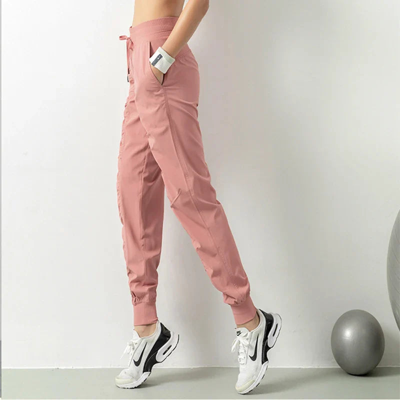 Premium women's sports trousers with drawstring waist and pockets, made of high-quality nylon fabric for comfort and versatility.