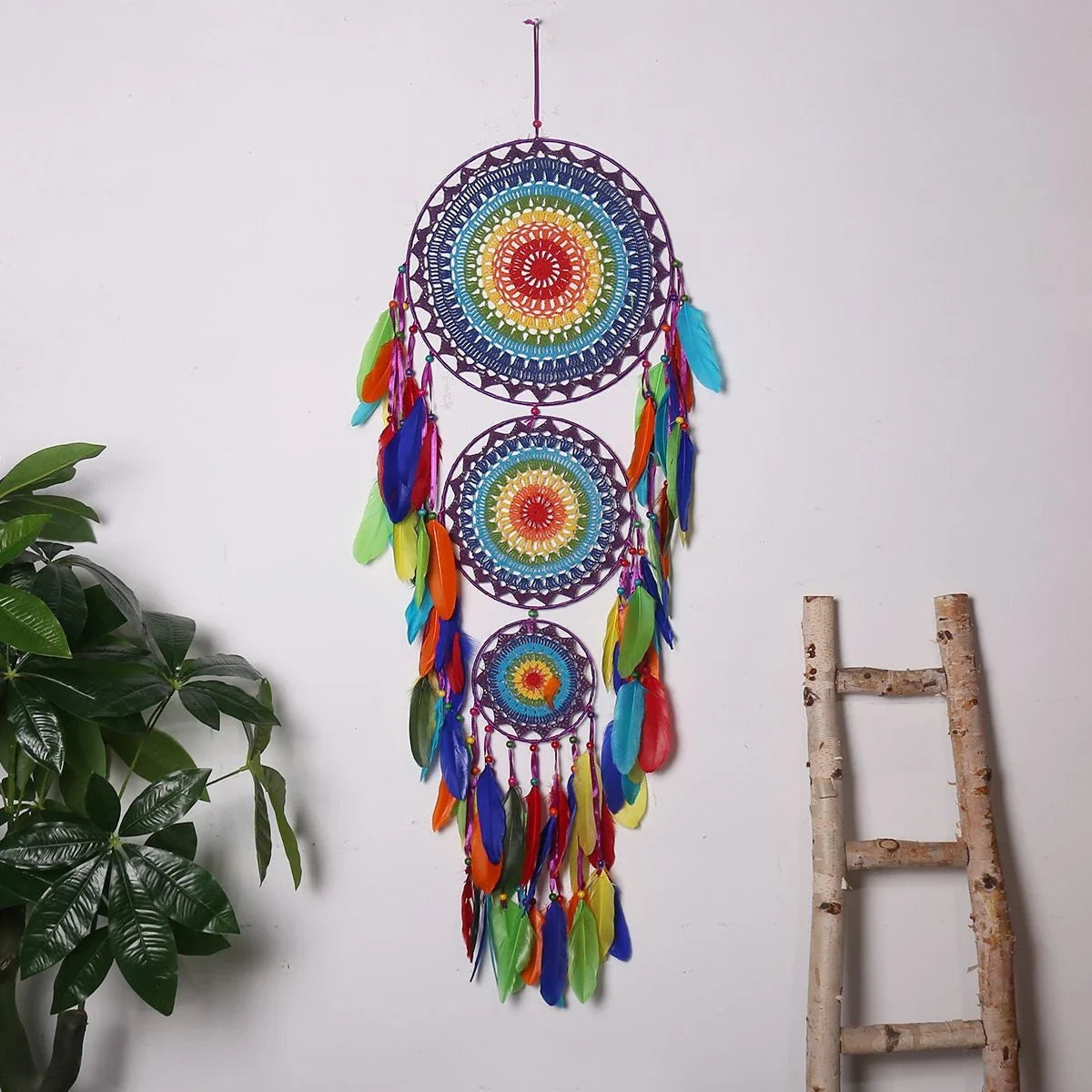 Colourful three-ring dreamcatcher wall hanging with feathers and beads, a unique and eye-catching home decor accent