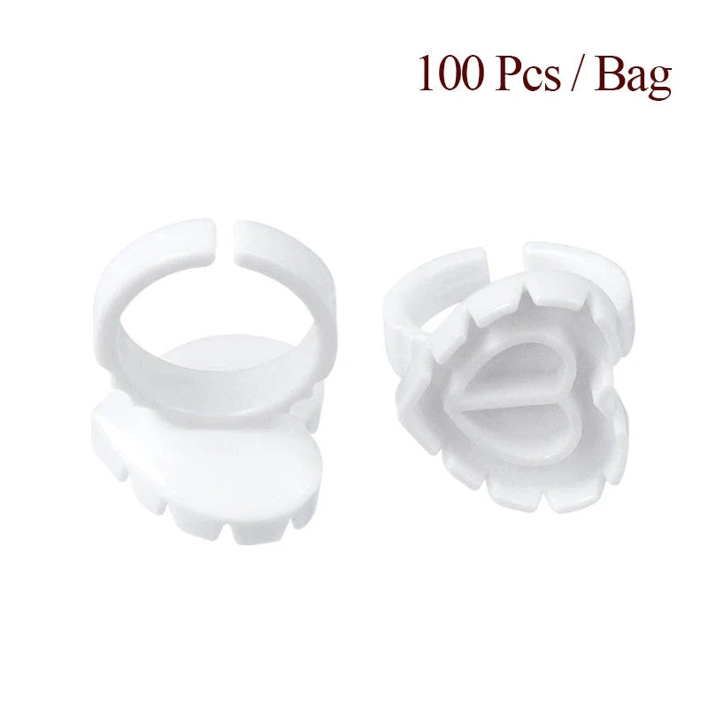 Heart-shaped disposable eyelash glue rings in blue, pink, and white colours