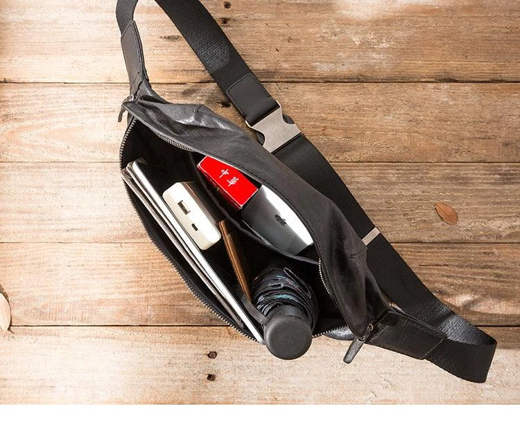 Premium cowhide messenger bag in black, featuring a spacious interior, adjustable shoulder strap, and sleek, minimalist design