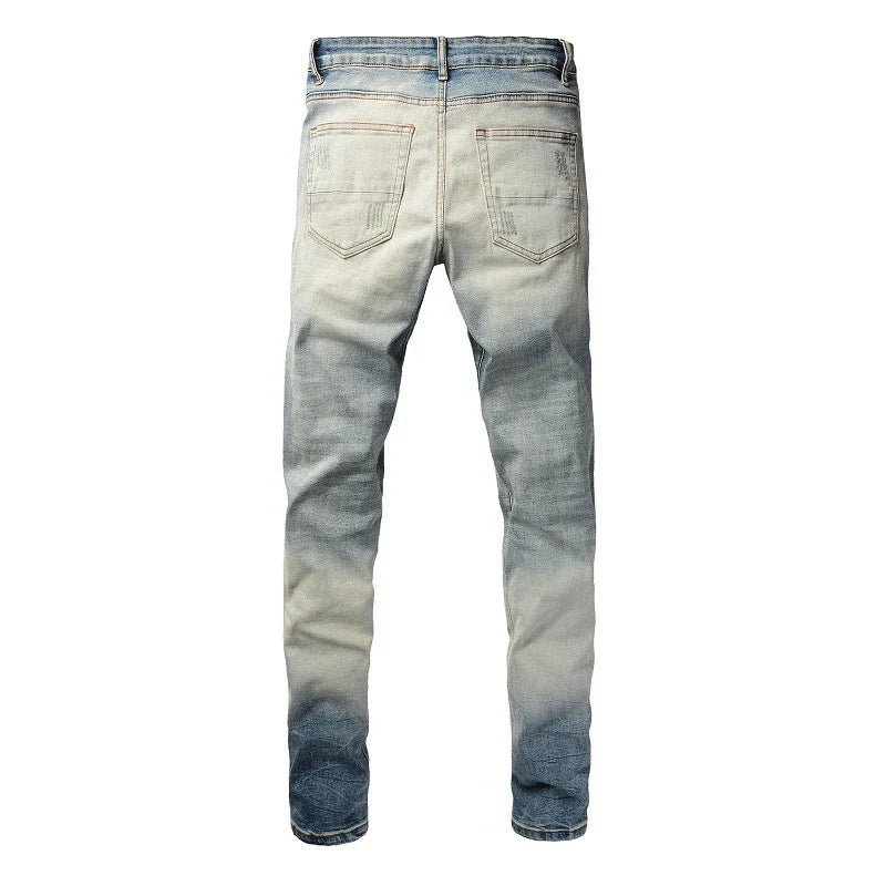 Stylish ripped denim jeans with a unique black and white patch design, perfect for British gentlemen