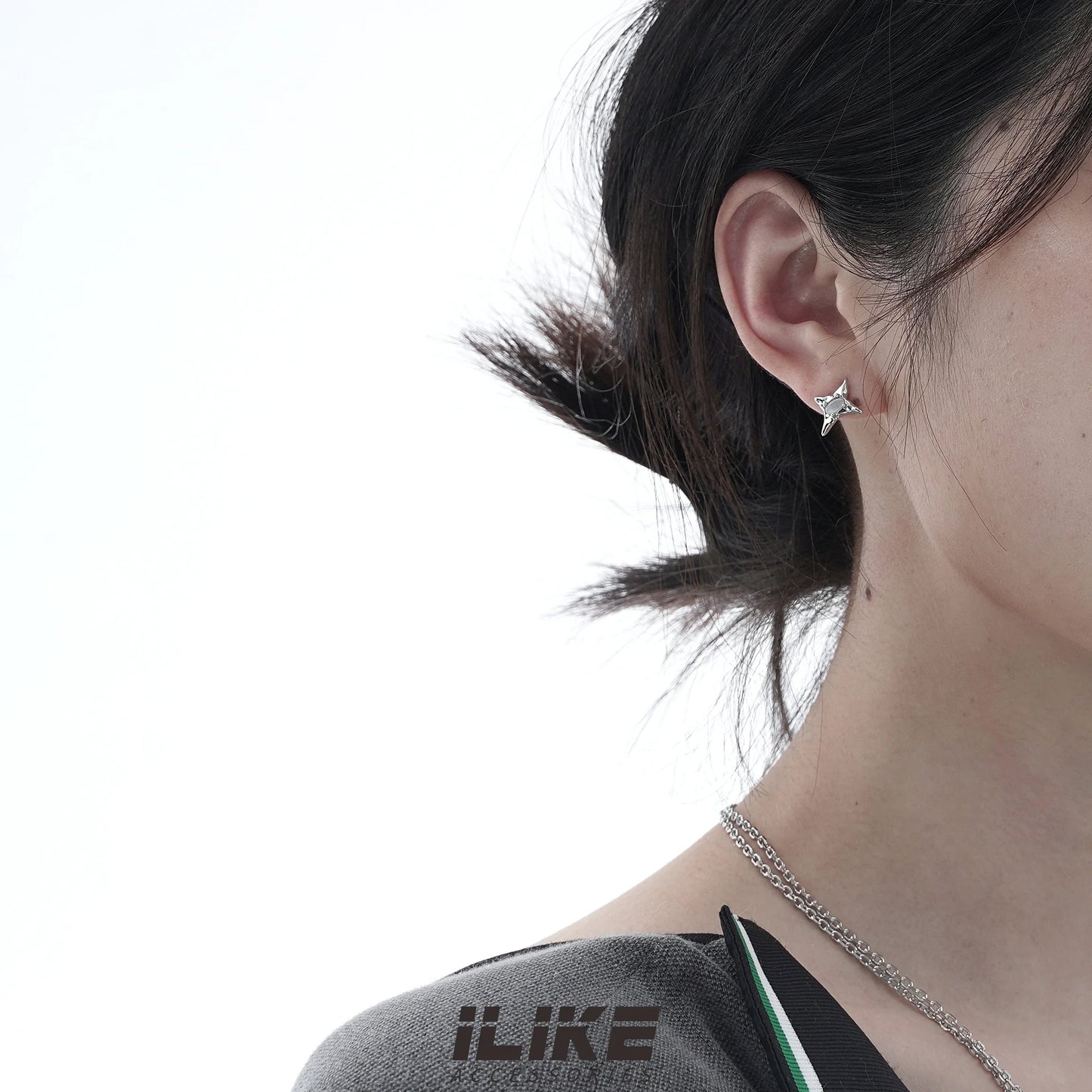 Pair of asymmetric silver stud earrings with intricate water drop and bell patterns, designed for modern British women