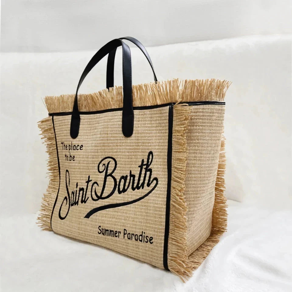 Stylish embroidered straw tote bag with playful tassels, perfect for summer outings and beach adventures.