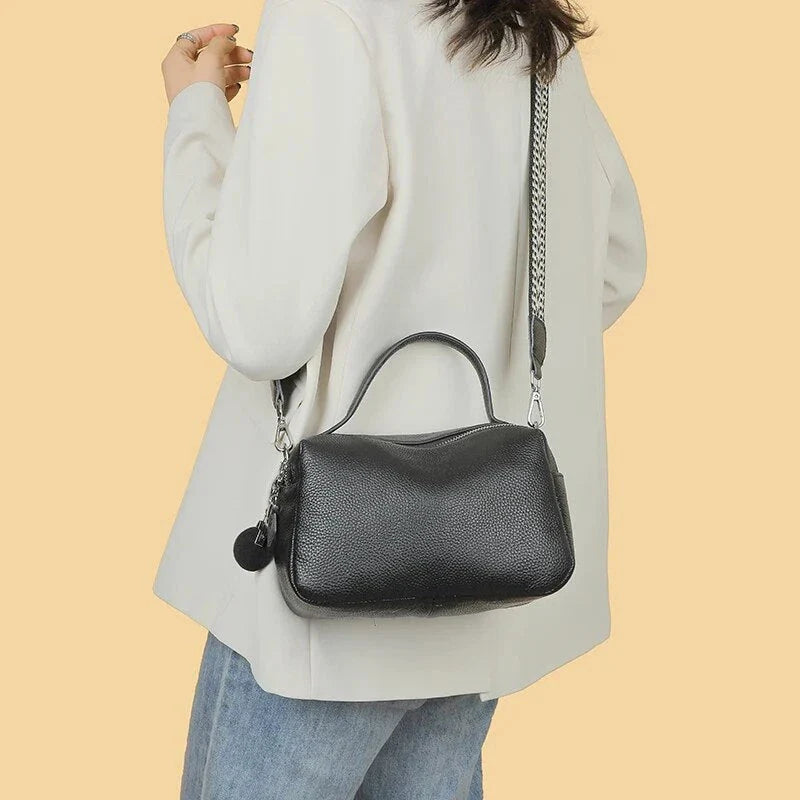 Luxurious genuine leather crossbody bag for women, featuring a soft polyester lining, dual phone pockets, and a compact, square design.