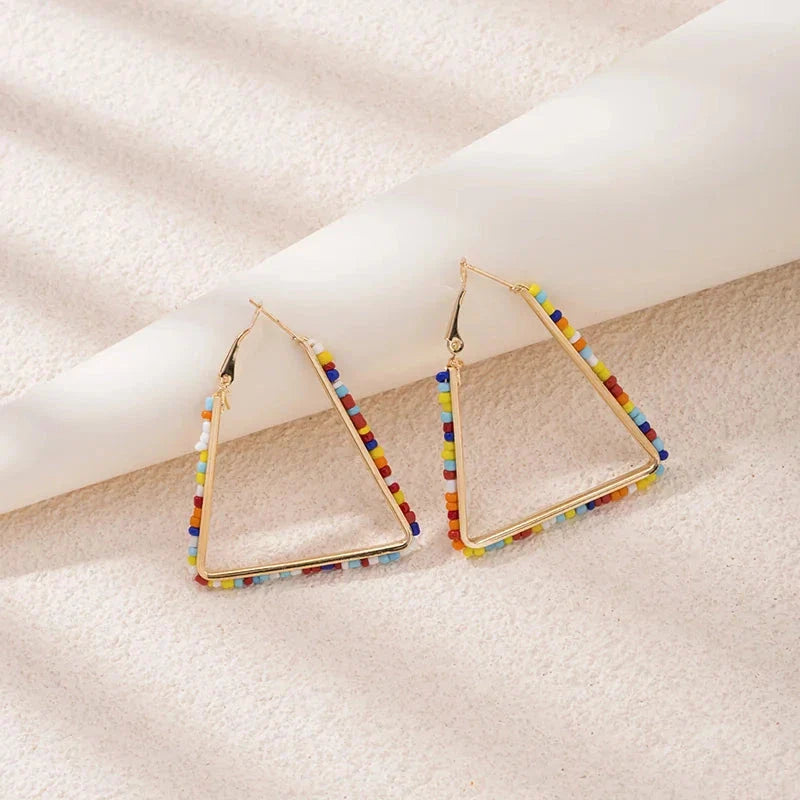 Colourful beaded triangle hoop earrings in gold metal with vibrant beadwork