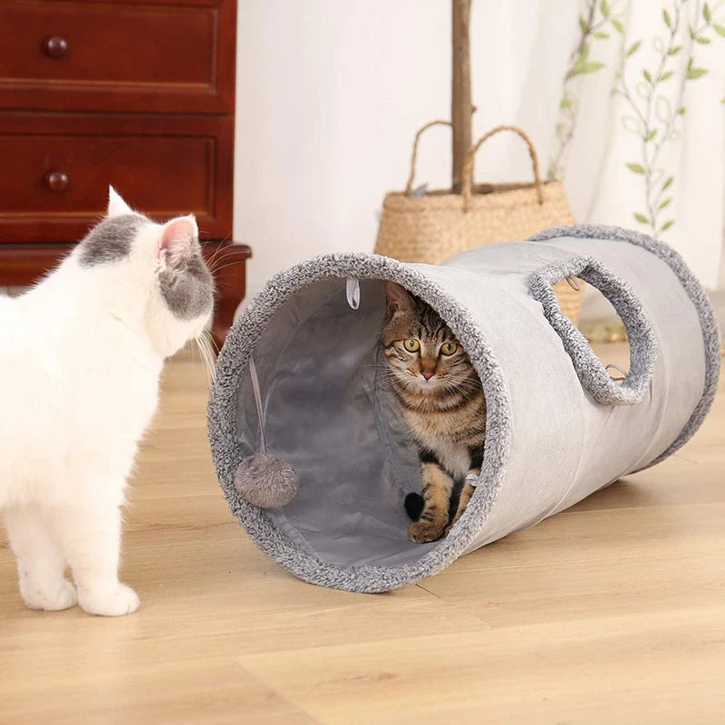 A collapsible cat tunnel made of crinkle suede with a peek-a-boo hole and dangling ball, providing a stimulating and entertaining play experience for cats.