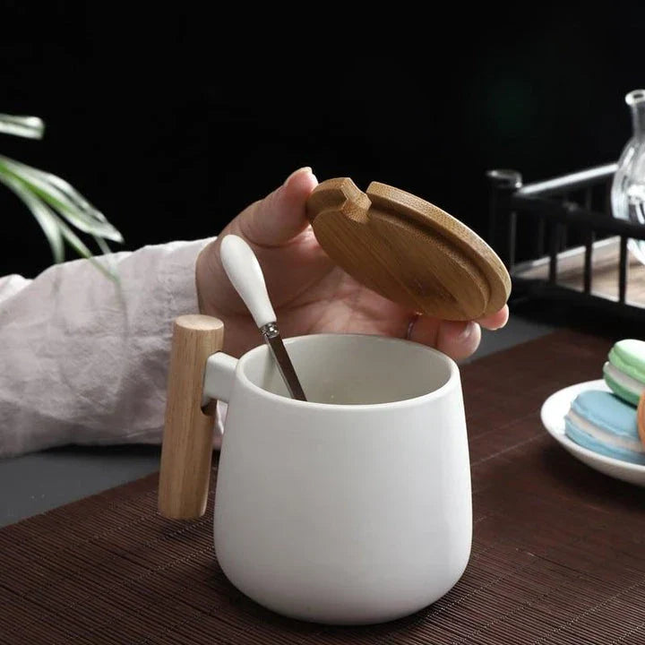 A stylish ceramic coffee mug with a colour block design and a coordinating wooden spoon