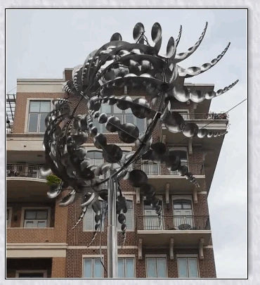 Elegant wind-powered kinetic sculpture with dual-motion blades and metallic construction, creating a mesmerizing visual display in any outdoor setting