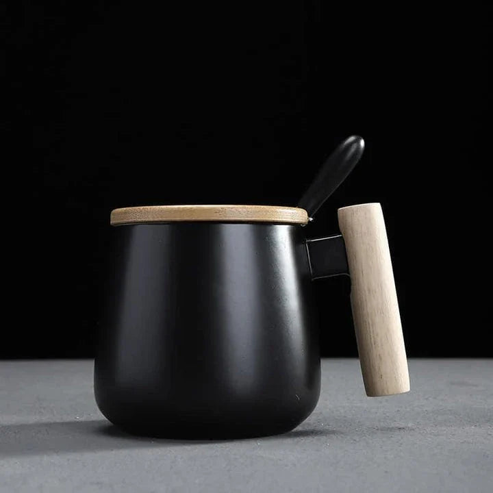 A stylish ceramic coffee mug with a colour block design and a coordinating wooden spoon