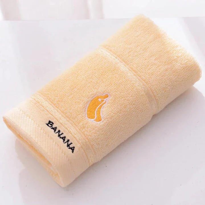 Soft cotton baby bath towel with adorable cartoon fruit face designs in pink