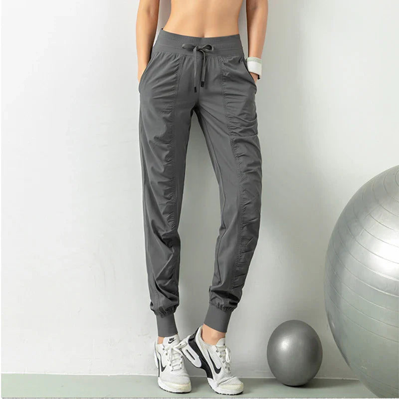 Premium women's sports trousers with drawstring waist and pockets, made of high-quality nylon fabric for comfort and versatility.