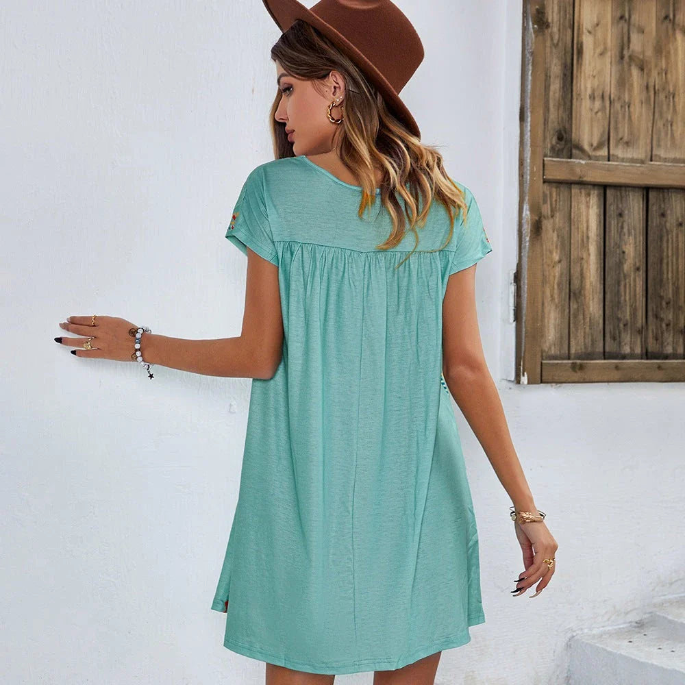 A stylish bohemian-inspired short dress with a geometric pattern, A-line silhouette, and short sleeves, suitable for warm weather