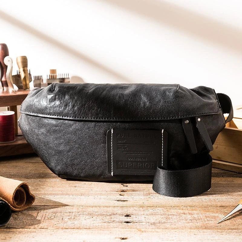 Premium cowhide messenger bag in black, featuring a spacious interior, adjustable shoulder strap, and sleek, minimalist design