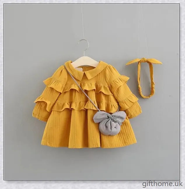 A beautiful summer dress for girls with a delicate floral pattern, long sleeves, and included accessories like a hair accessory and handbag