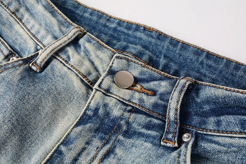 Stylish ripped denim jeans with a unique black and white patch design, perfect for British gentlemen