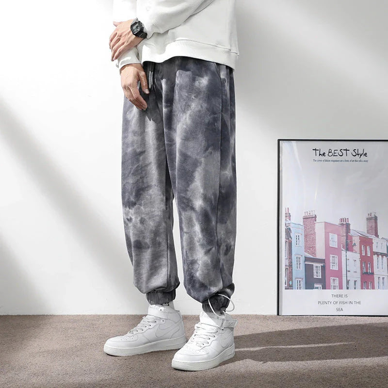 Stylish ankle-tied sweatpants in camouflage black, featuring an elasticated waistband, drawstring, and ankle ties for a relaxed yet refined look.