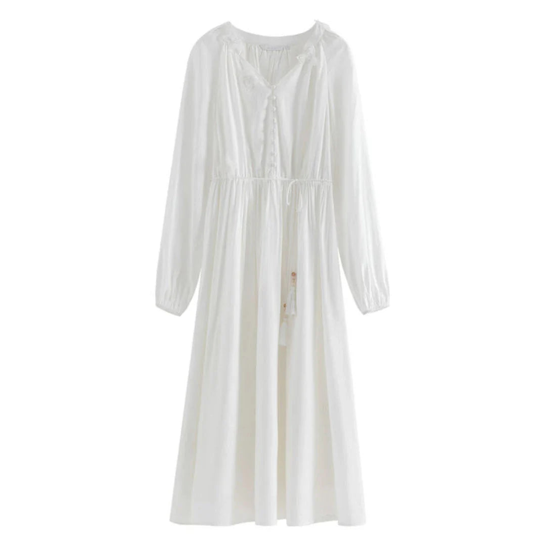 A woman wearing a long-sleeved, midi-length dress in a French pastoral style with an empire waistline and A-line silhouette.