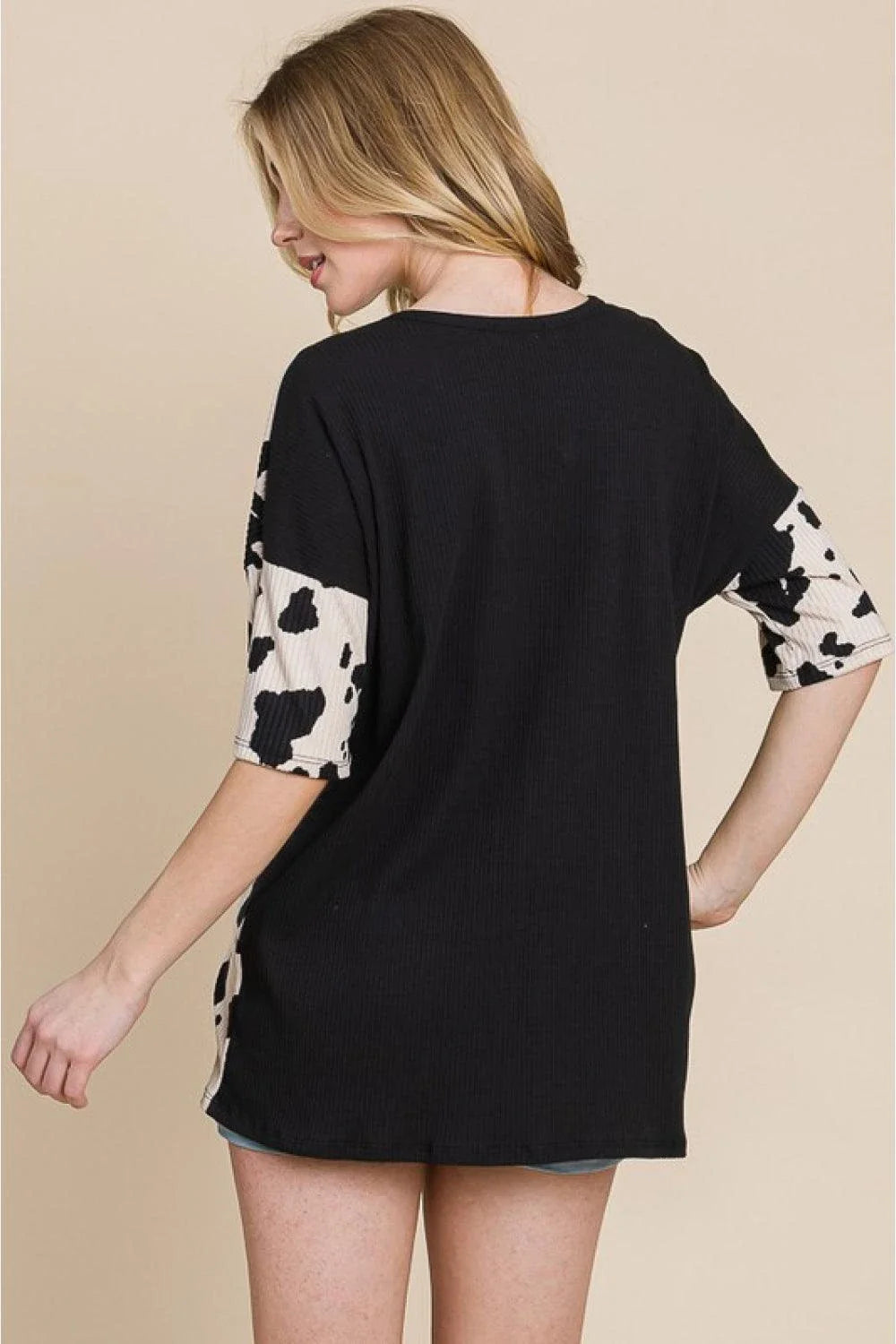 Stylish ribbed tee with playful cow print design, perfect for casual and smart-casual occasions.