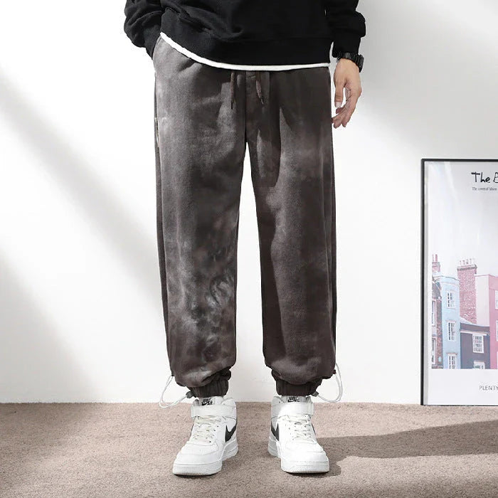 Stylish ankle-tied sweatpants in camouflage black, featuring an elasticated waistband, drawstring, and ankle ties for a relaxed yet refined look.