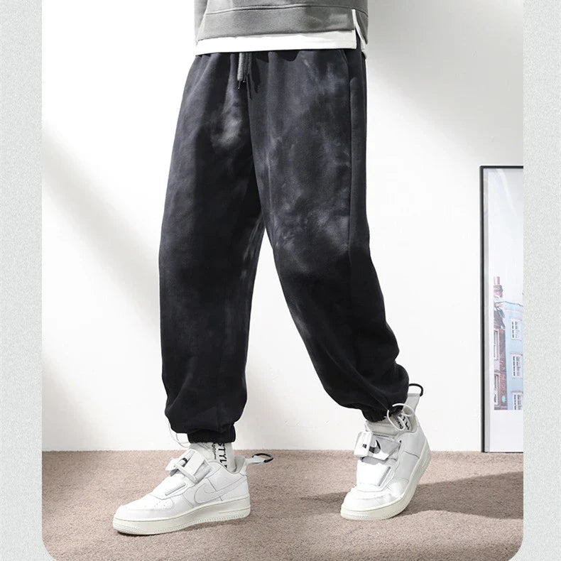 Stylish ankle-tied sweatpants in camouflage black, featuring an elasticated waistband, drawstring, and ankle ties for a relaxed yet refined look.