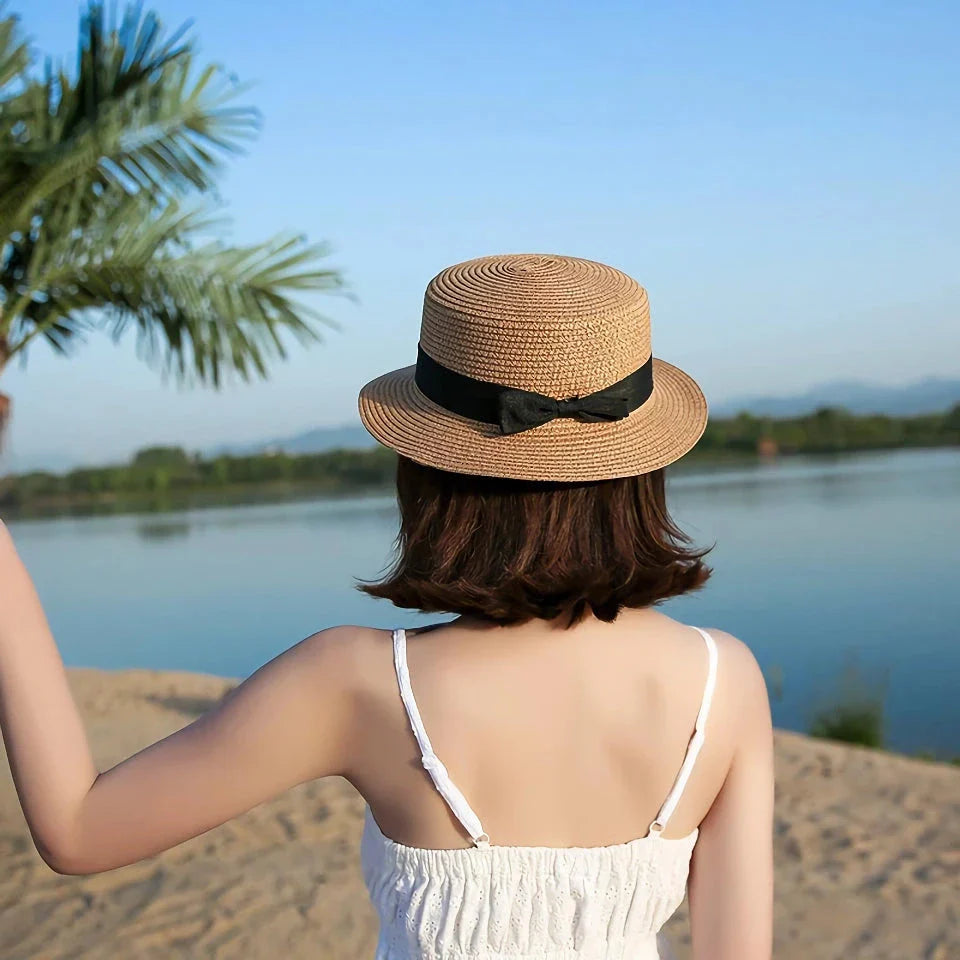 A classic summer Panama hat made from straw and paper, featuring a charming bow detail that adds a feminine touch.